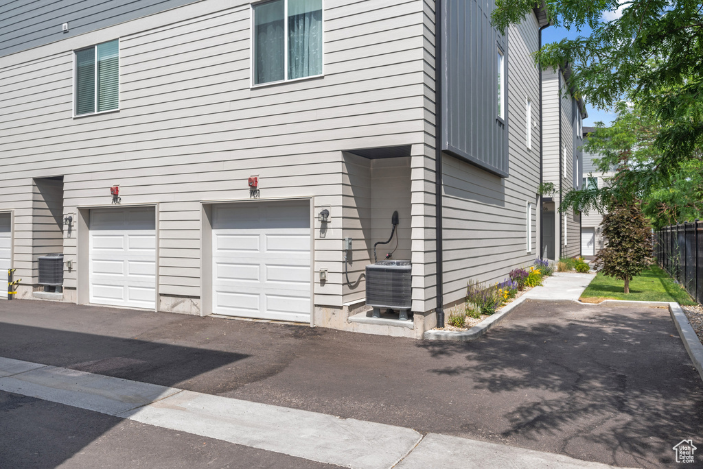 View of side of property featuring a central air condition unit and an attached garage
