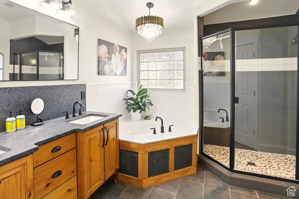 Full bath featuring a shower stall, wainscoting, double vanity, a garden tub, and tile patterned floors