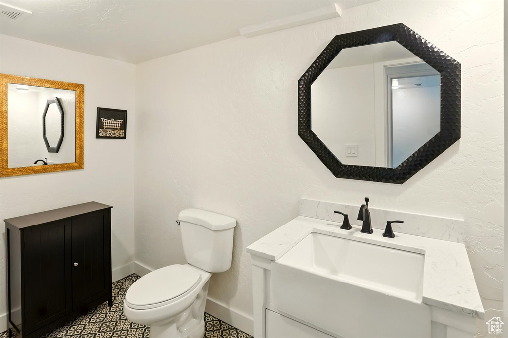 Half bathroom with vanity and toilet