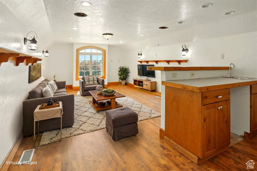 Living area featuring a textured ceiling and wood finished floors