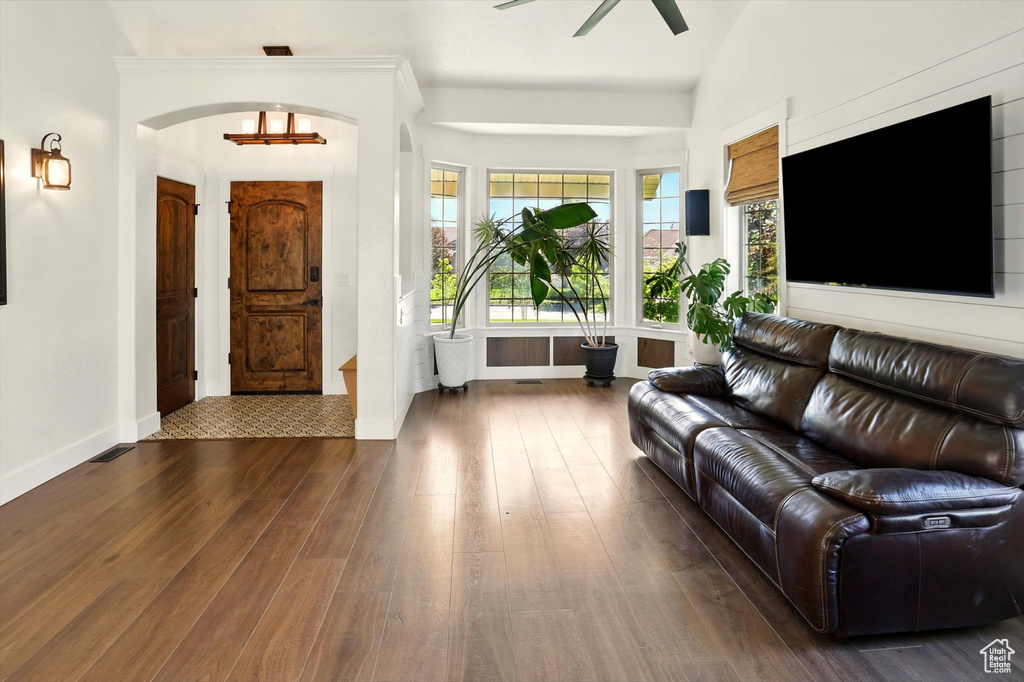 Living room featuring hardwood / wood-style flooring, a ceiling fan, plenty of natural light, and arched walkways
