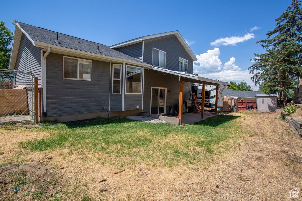 Rear view of house with a patio and a shed