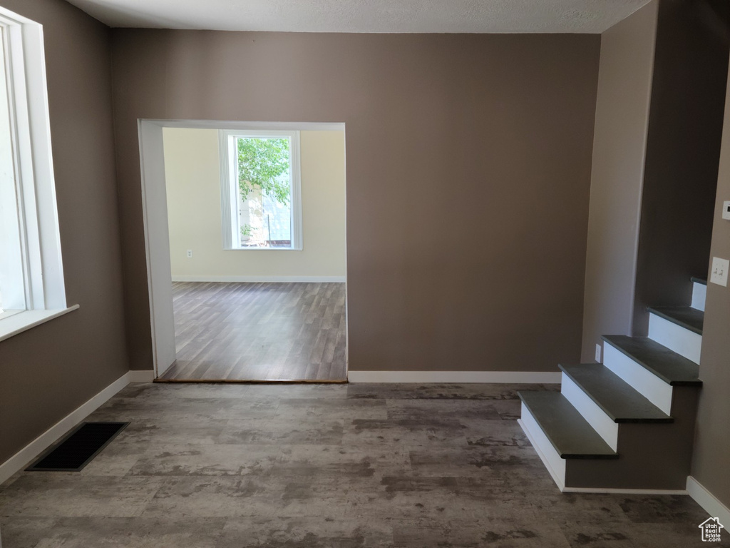 Unfurnished room with baseboards, wood finished floors, and stairway