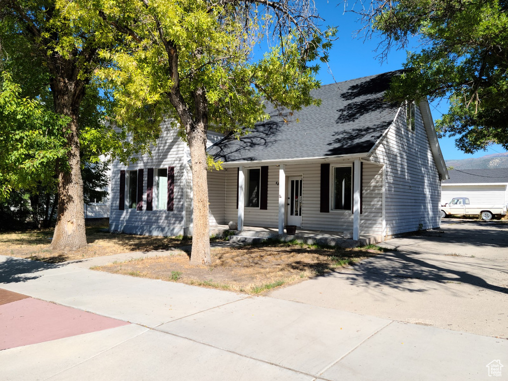 View of front of property with covered porch and a shingled roof