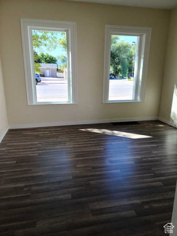 Unfurnished room with dark wood-type flooring and baseboards
