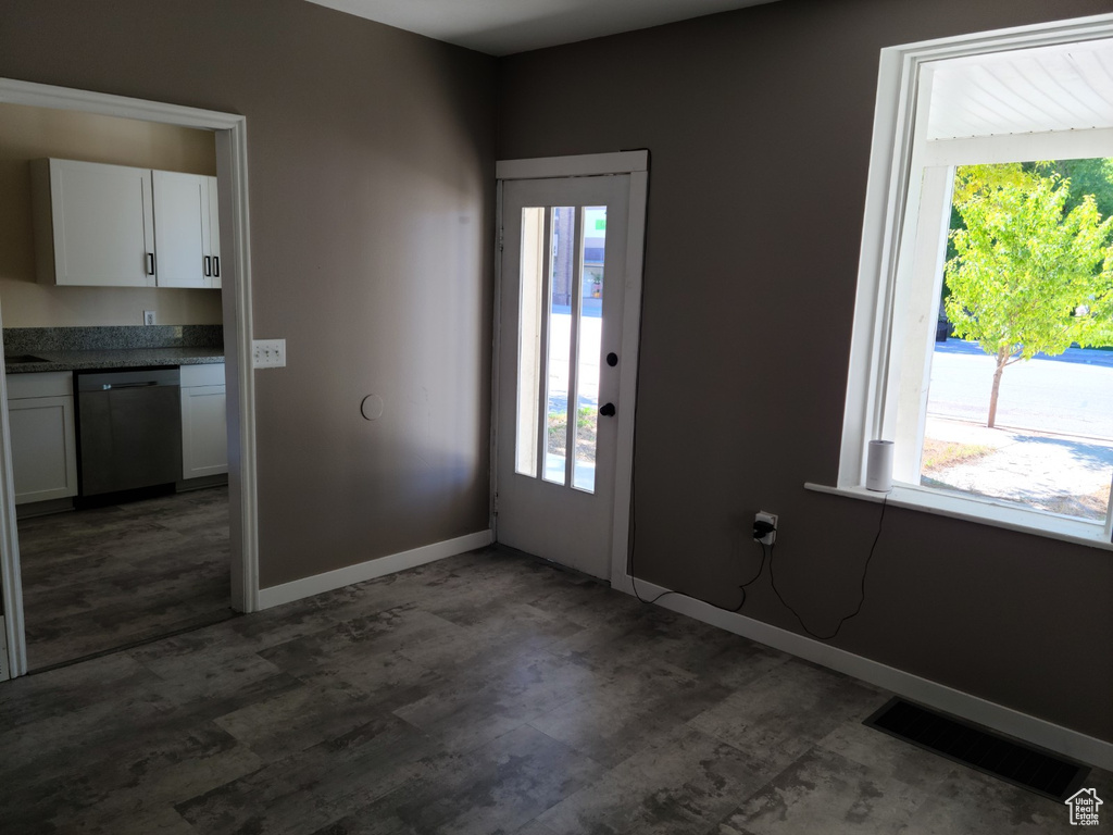 Entrance foyer featuring healthy amount of natural light, dark wood finished floors, and baseboards