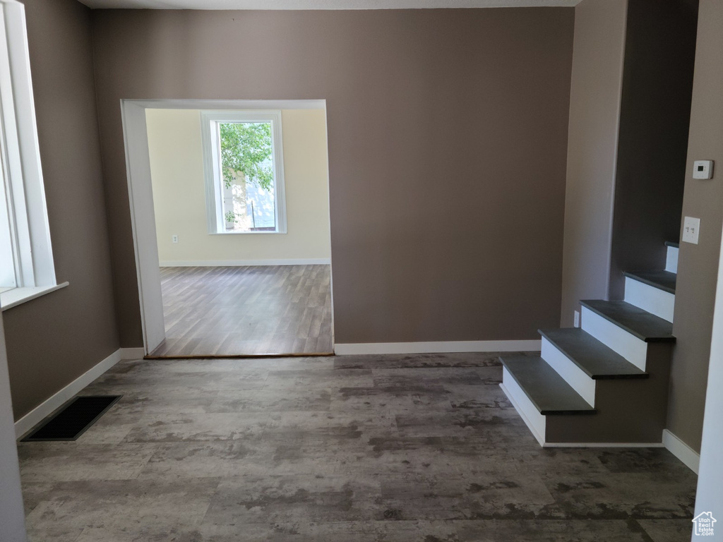 Spare room featuring baseboards, wood finished floors, and stairway