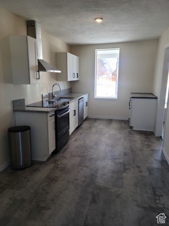 Kitchen featuring electric range oven, stainless steel dishwasher, baseboards, a sink, and a textured ceiling