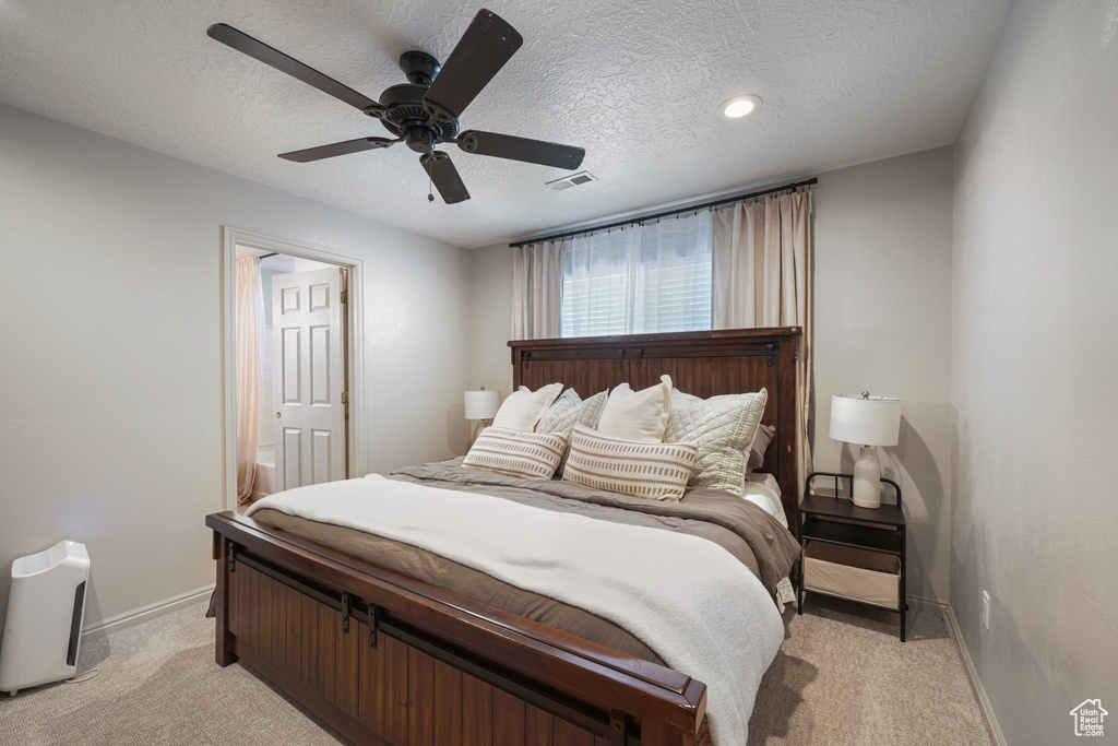 Bedroom featuring light colored carpet, a textured ceiling, ceiling fan, ensuite bathroom, and recessed lighting