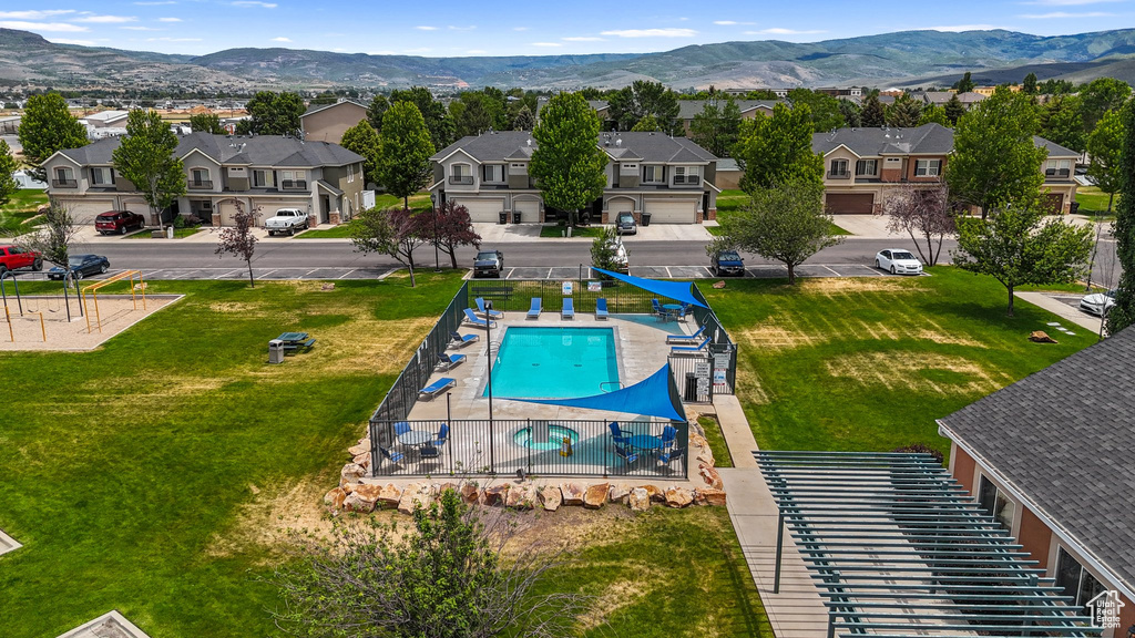 Aerial perspective of suburban area with mountains and a pool