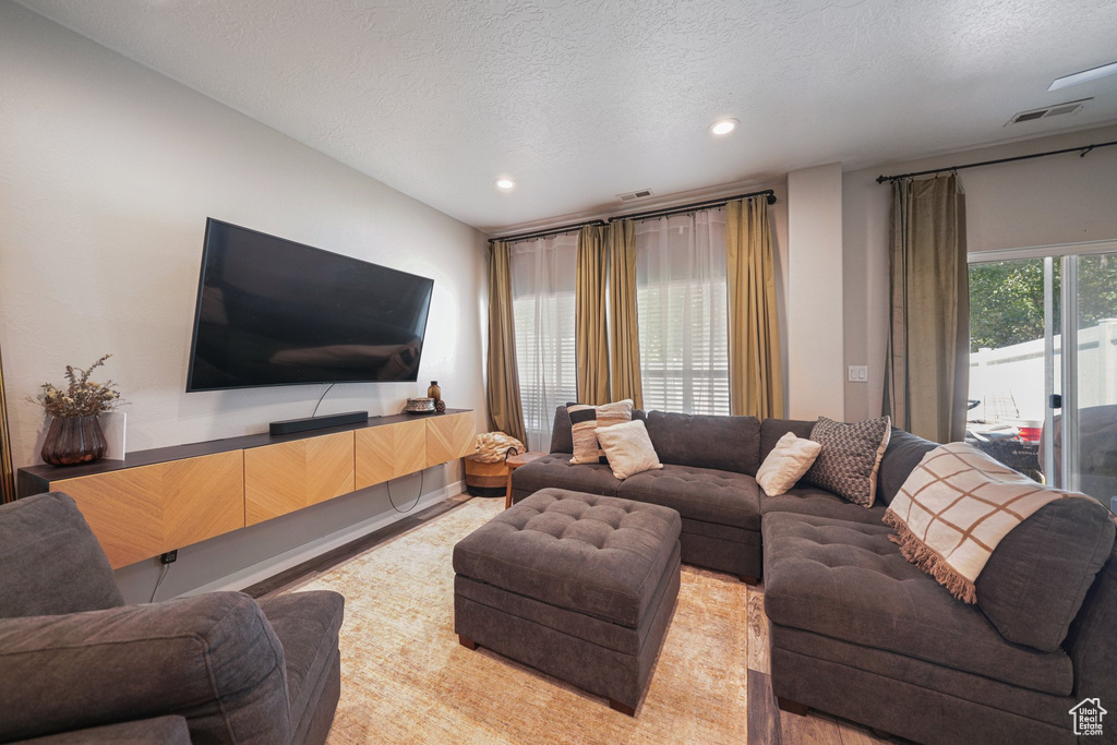 Living area featuring a textured ceiling and recessed lighting