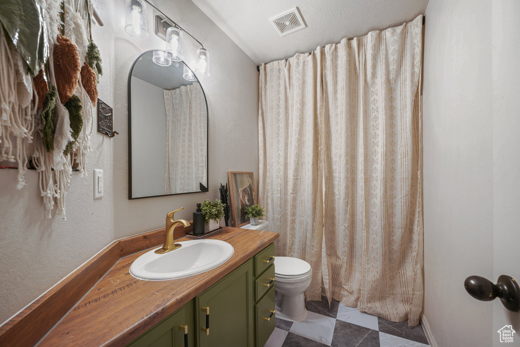 Bathroom with vanity, tile patterned floors, and curtained shower