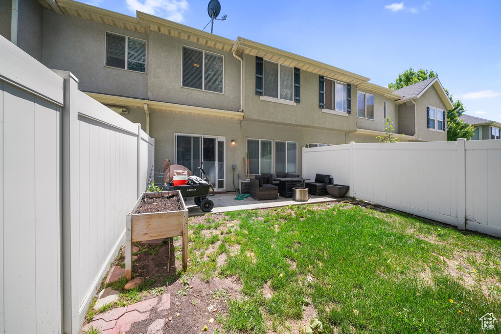 Back of house with an outdoor living space, a fenced backyard, a patio, and stucco siding