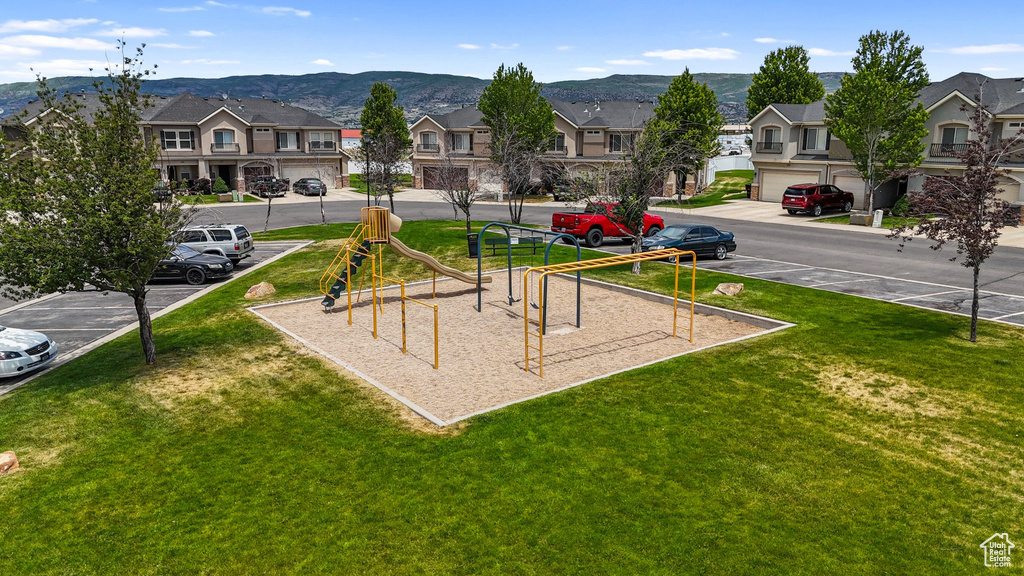 Community jungle gym with a residential view, a yard, and a mountain view