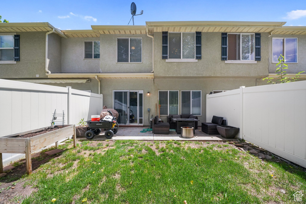 Rear view of house with an outdoor living space, a vegetable garden, stucco siding, and a fenced backyard