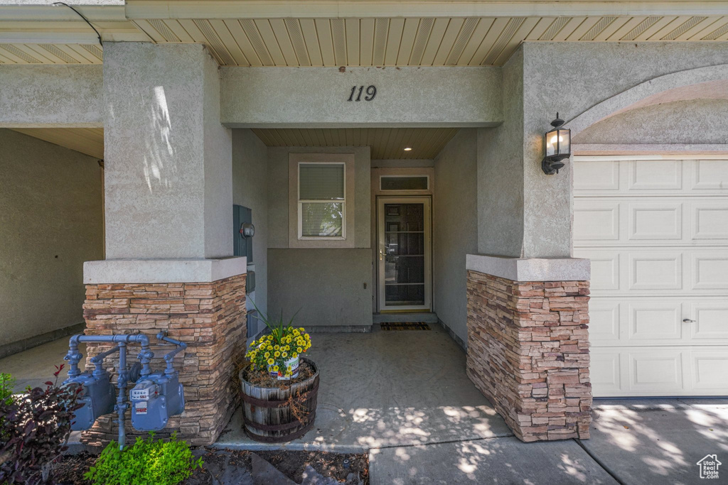Doorway to property featuring stucco siding and stone siding