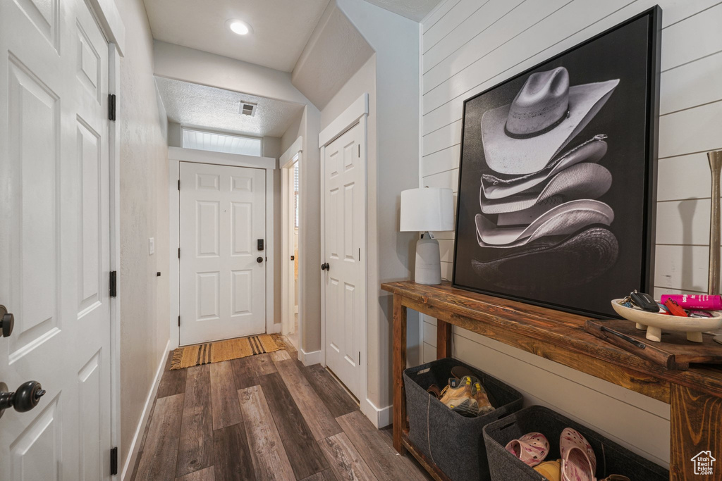Foyer with dark wood-style floors and baseboards
