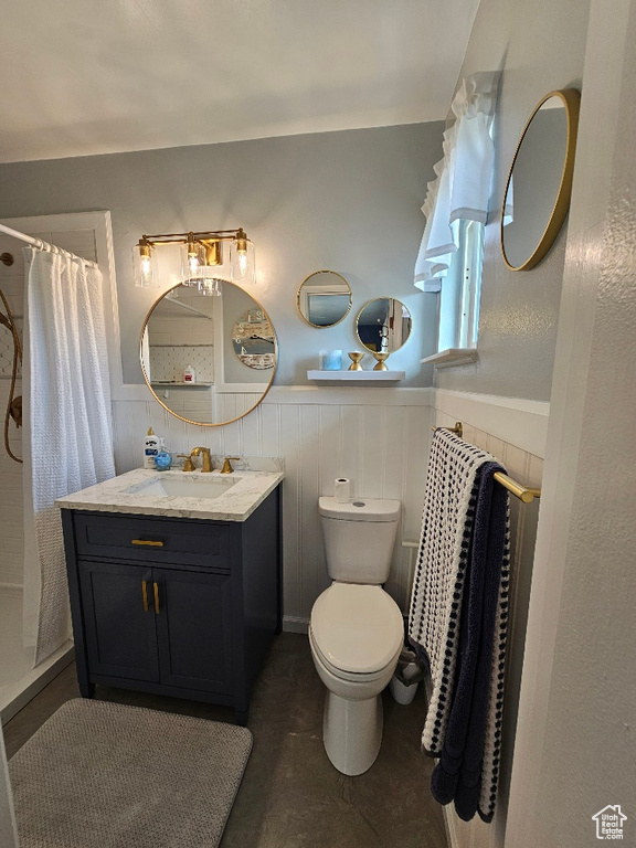 Bathroom with wainscoting, vanity, and a shower with shower curtain
