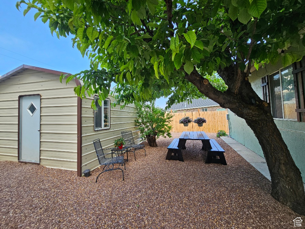 Fenced backyard featuring an outdoor structure and outdoor dining area
