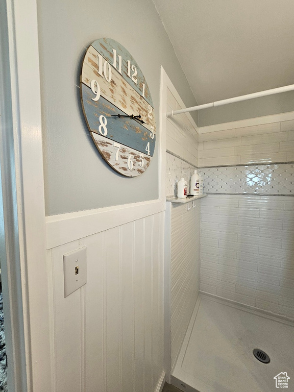 Bathroom with tiled shower and wainscoting