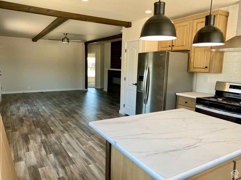 Kitchen featuring appliances with stainless steel finishes, beamed ceiling, decorative backsplash, open floor plan, and wall chimney range hood