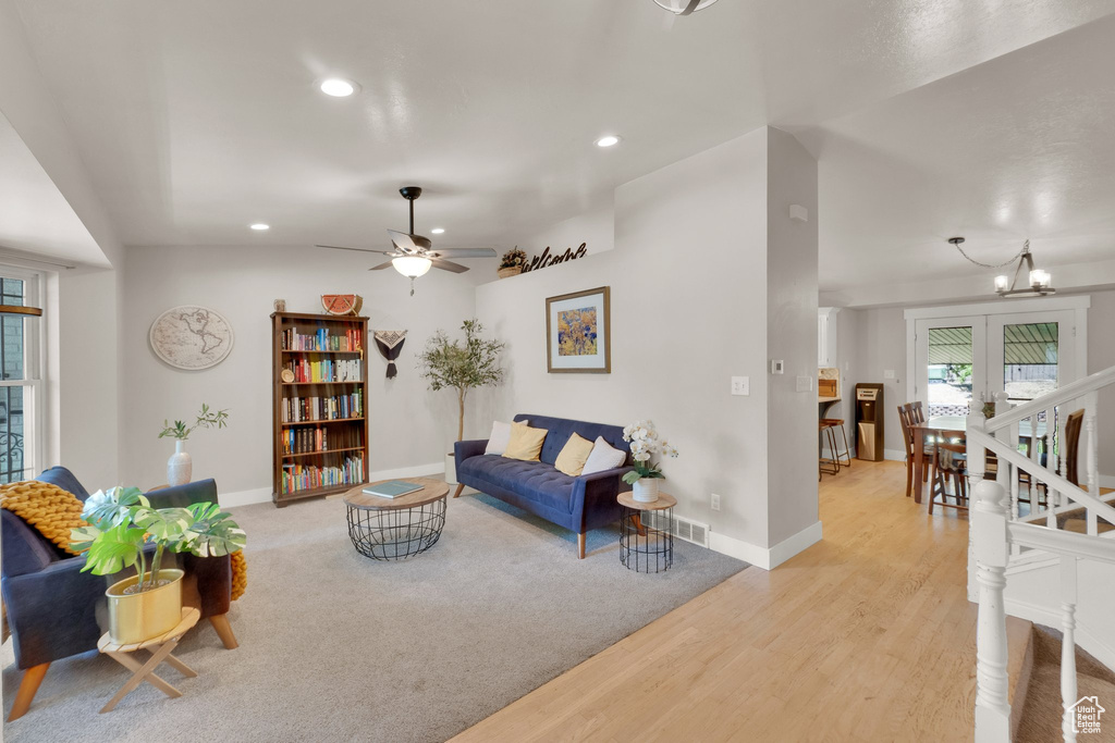 Living room featuring recessed lighting, light wood-style floors, a chandelier, and a ceiling fan