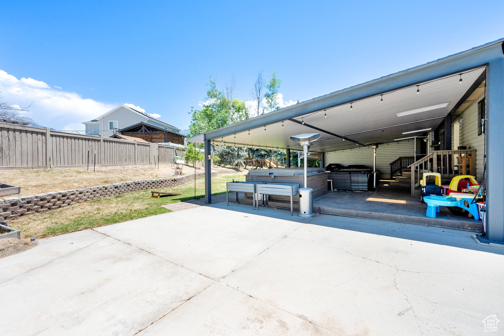 Fenced backyard with a hot tub and a patio area