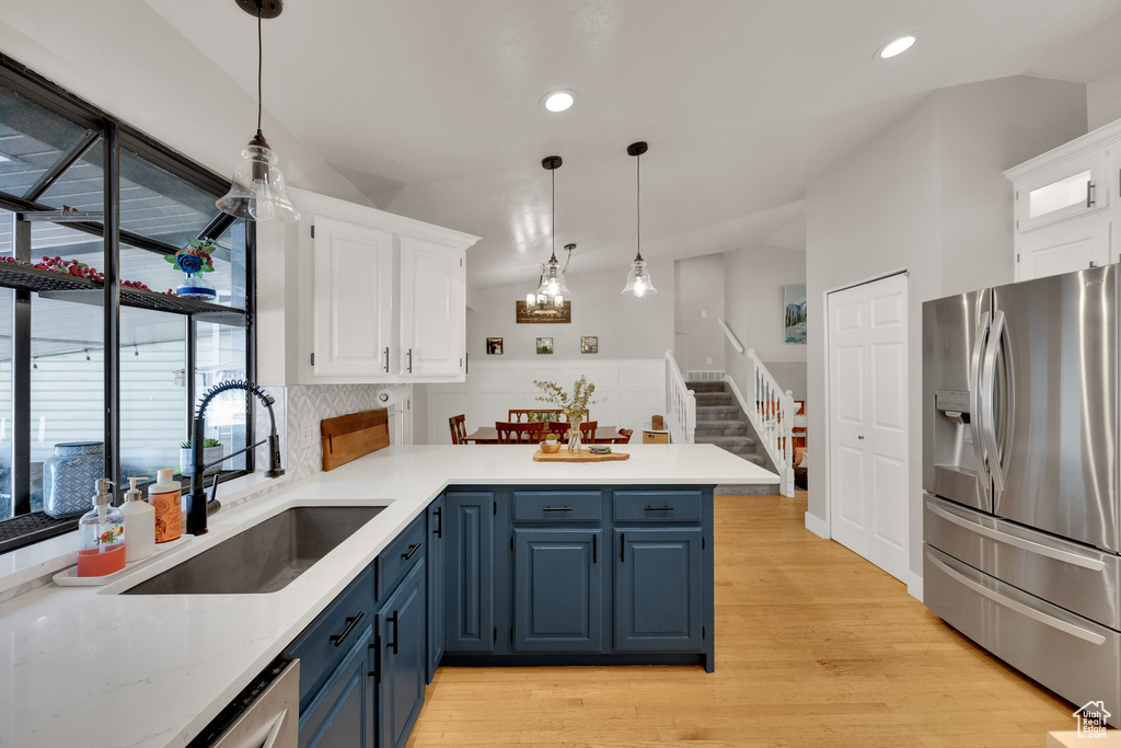Kitchen featuring stainless steel appliances, blue cabinets, a peninsula, white cabinets, and recessed lighting