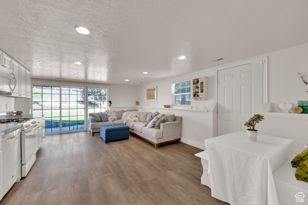 Living room with light wood finished floors and recessed lighting