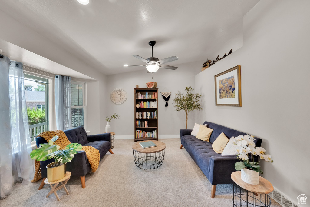 Carpeted living area featuring a ceiling fan and recessed lighting