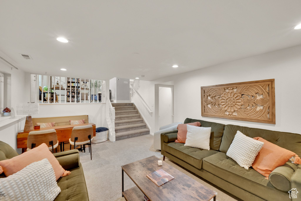 Carpeted living room with stairway and recessed lighting