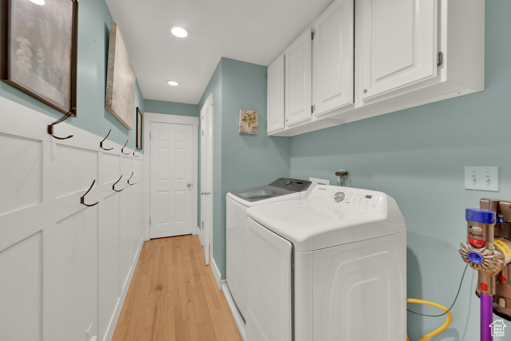 Laundry area with washer and dryer, cabinet space, light wood-style floors, and recessed lighting