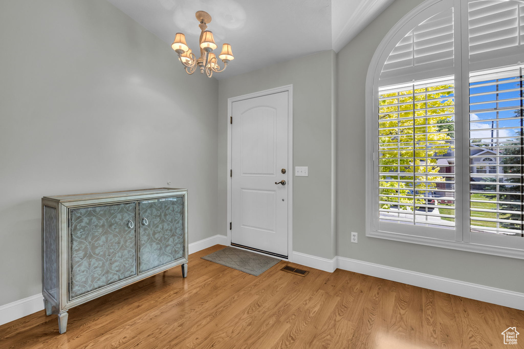 Foyer entrance with a chandelier and wood finished floors