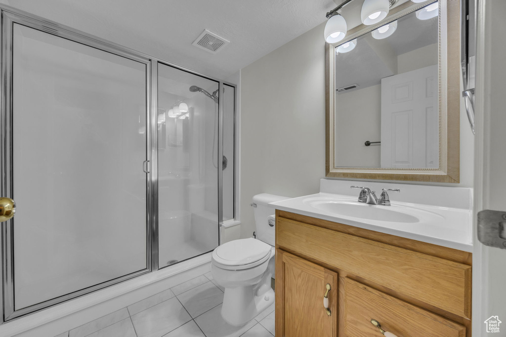 Bathroom featuring a shower stall, vanity, and tile patterned floors