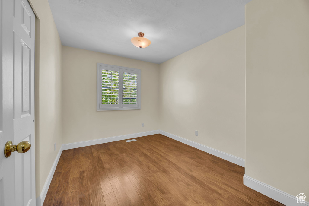 Unfurnished room with wood finished floors and baseboards