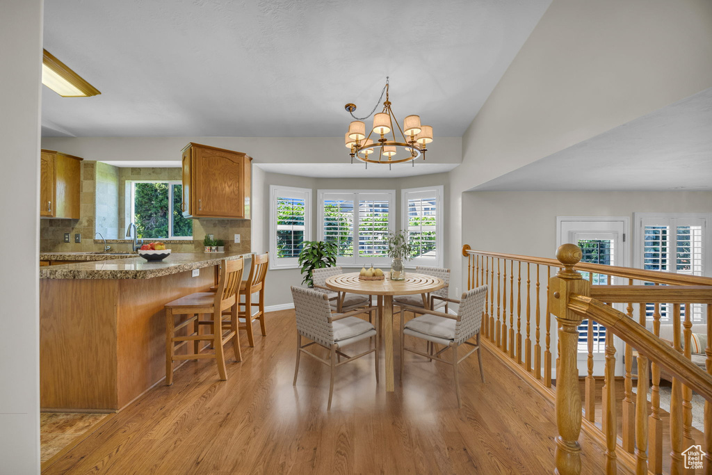 Dining area featuring plenty of natural light, light wood finished floors, and a chandelier