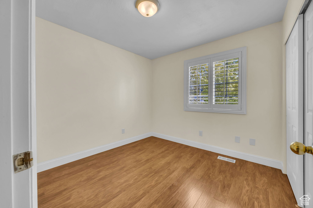 Unfurnished room with wood finished floors and baseboards