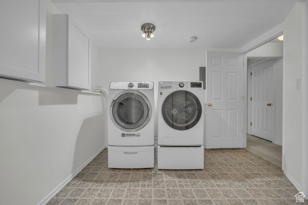 Laundry area featuring cabinet space and separate washer and dryer