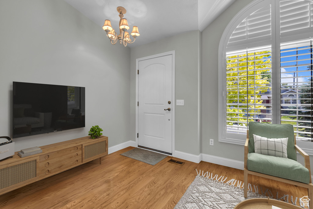 Entrance foyer featuring a chandelier, wood finished floors, and healthy amount of natural light
