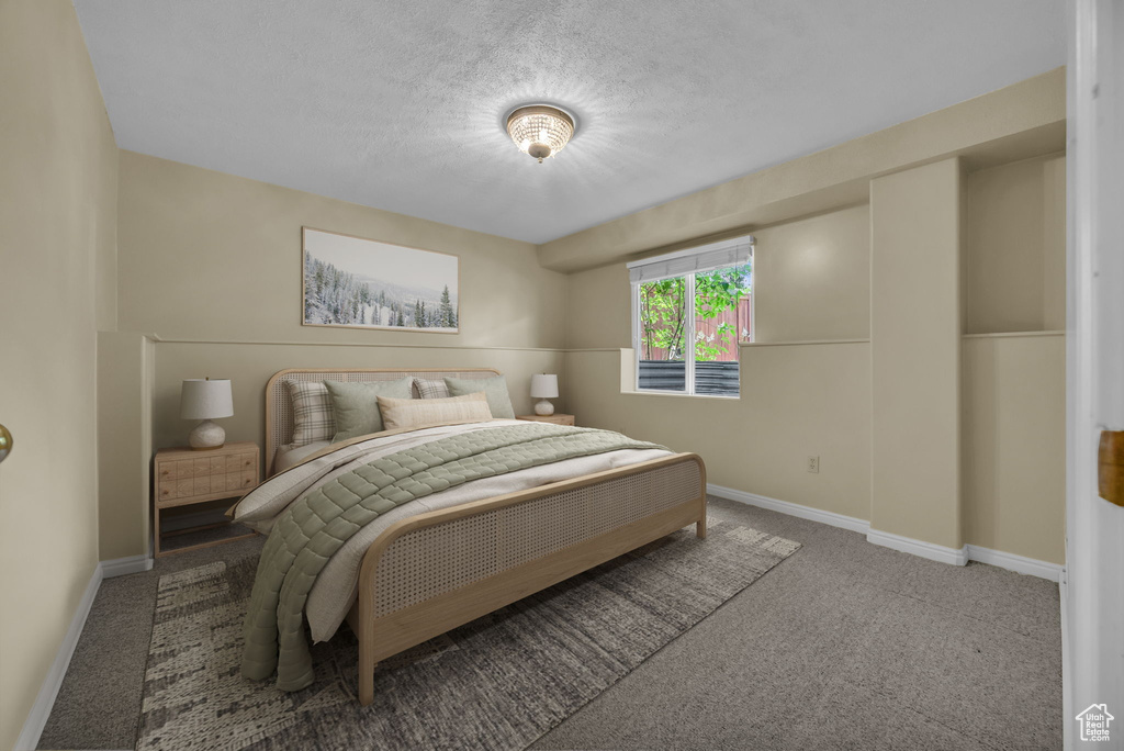 Carpeted bedroom with baseboards and a textured ceiling