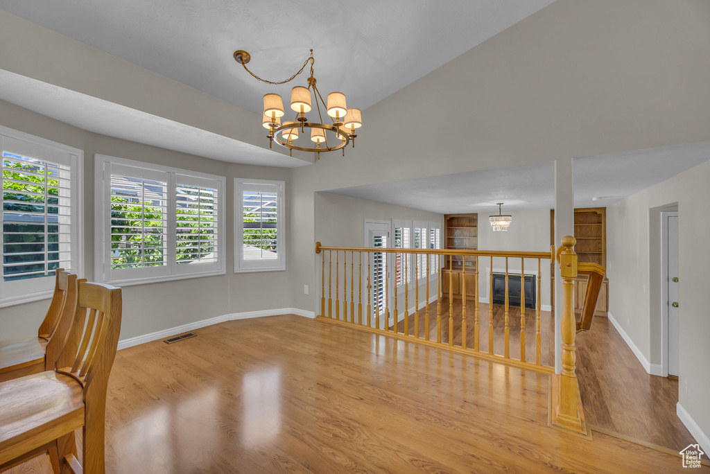 Unfurnished room with a chandelier and wood finished floors