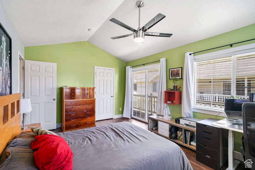 Bedroom with dark wood-style flooring, vaulted ceiling, access to exterior, and ceiling fan
