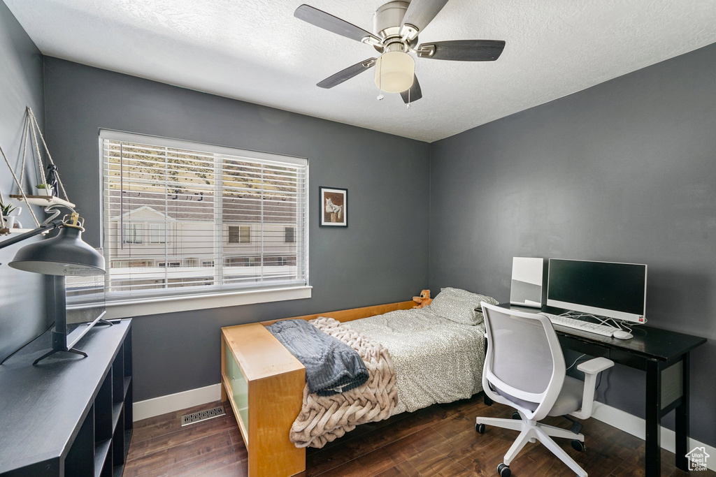 Bedroom with wood finished floors, a textured ceiling, and ceiling fan