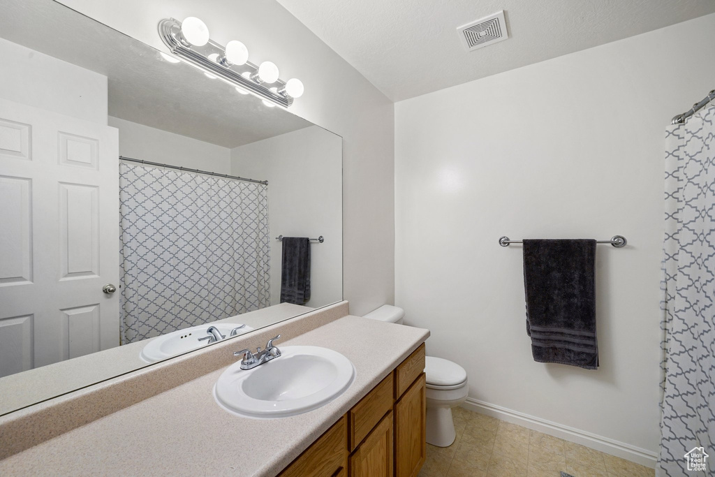 Bathroom with vanity, curtained shower, and tile patterned floors