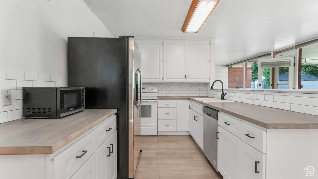 Kitchen with a sink, stainless steel appliances, and decorative backsplash