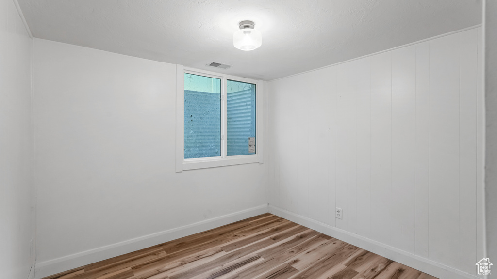Unfurnished room with light wood-style flooring and baseboards