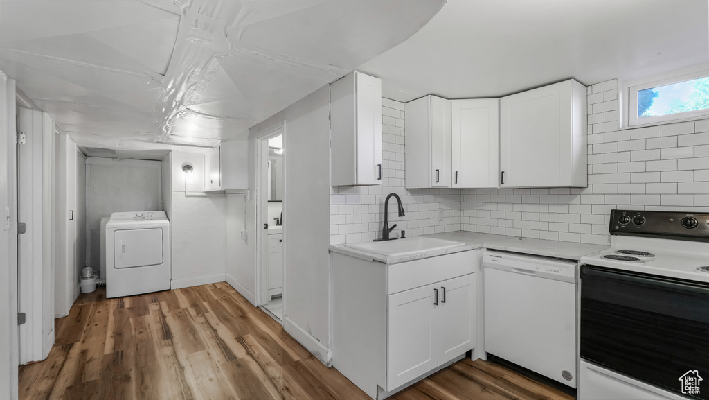Kitchen featuring white appliances, washer / dryer, a sink, and light countertops