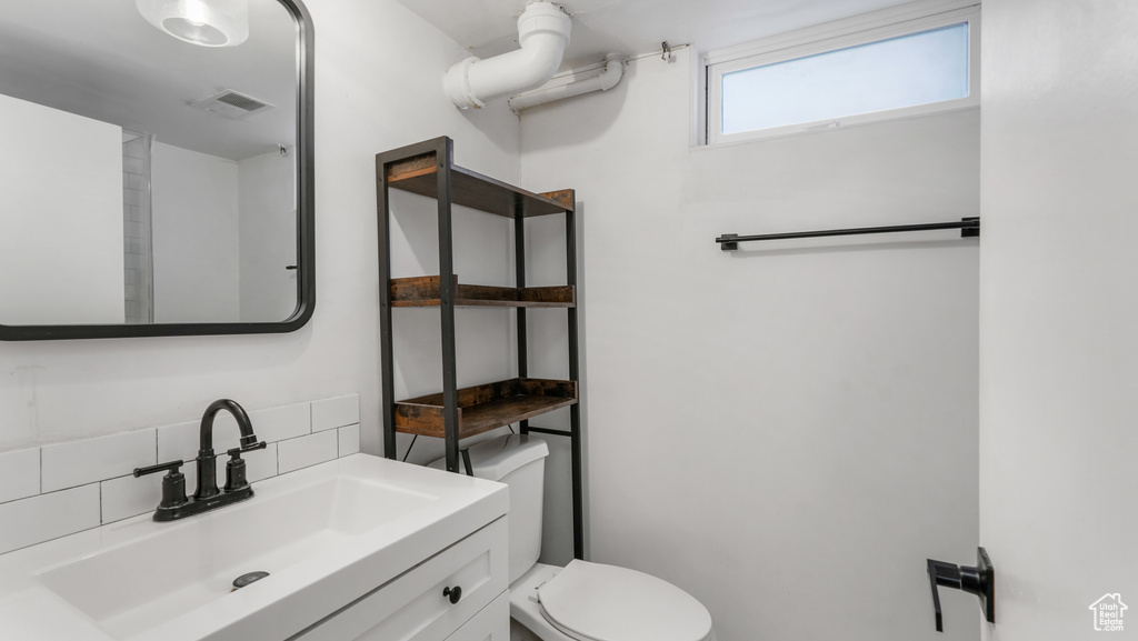 Bathroom with tasteful backsplash, toilet, and vanity