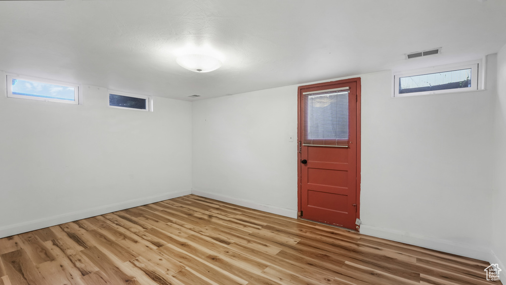 Below grade area with light wood-style flooring and baseboards