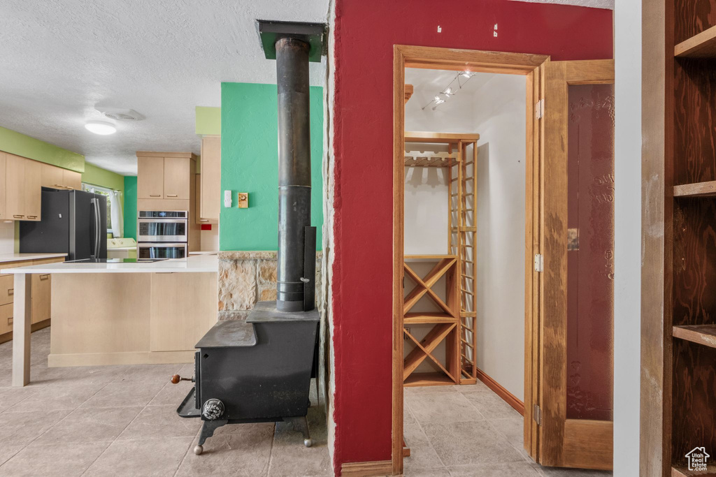 Hall featuring light tile patterned floors and a textured ceiling